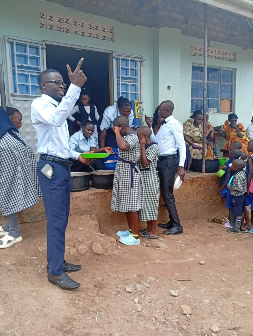 A staff member serving a meal to pupils