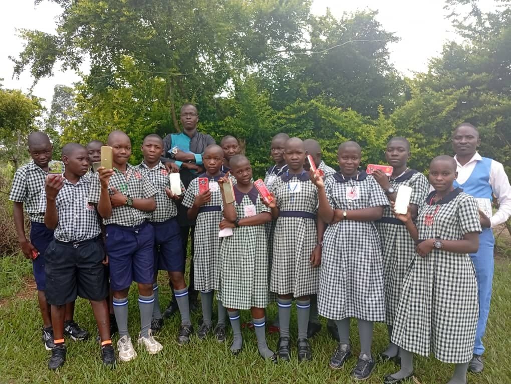Pupils holding up scholastic materials received during a donation day at St. Mary's